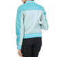 The back view of a woman wearing a turquoise leather bomber jacket.