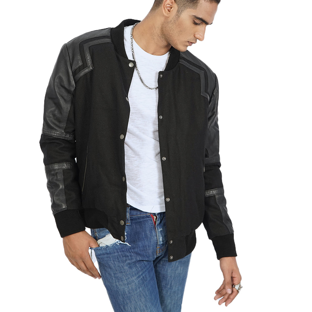  A man wearing an Alexander Varsity Jacket and jeans. A man wearing an Alexander Varsity Jacket and jeans.